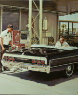 Two people on an Impala XW refuelling at a gas station