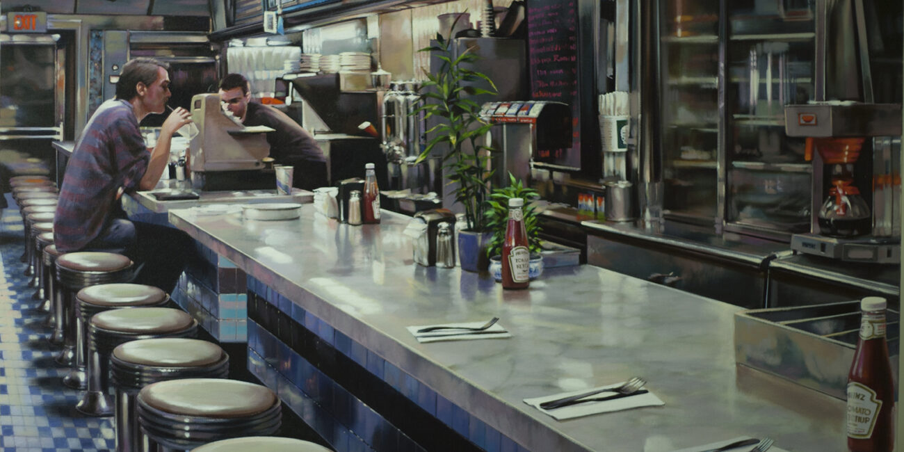 A man drinking a coffee in a diner