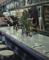 A man drinking a coffee in a diner