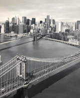A black and white aerial view of New York seen from above the bridge